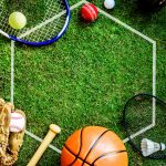 Strumenti di diverse discipline sportive su prato, simbolo di orientamento e scelta