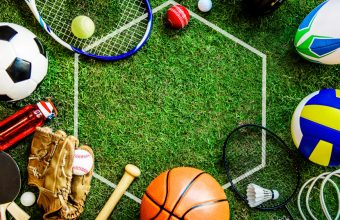 Strumenti di diverse discipline sportive su prato, simbolo di orientamento e scelta