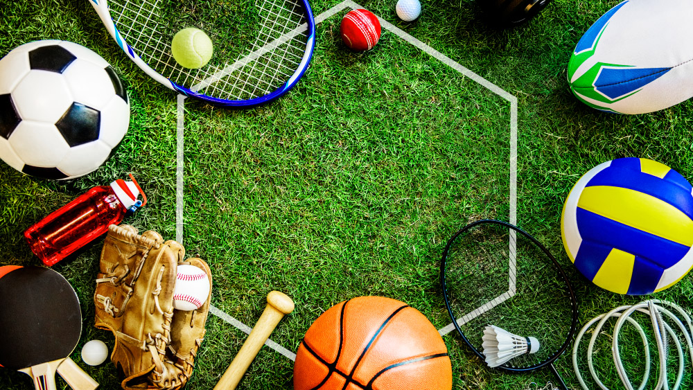 Strumenti di diverse discipline sportive su prato, simbolo di orientamento e scelta